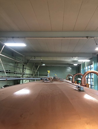Multiple radar level sensors installed on top of different fermentation vessels in a distillery.