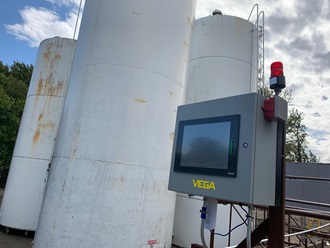 A VCCS13e display cabinet sits in the foreground of petroleum product bulk storage tanks