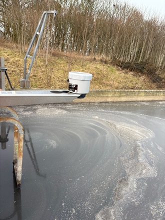 Ein Radar-Füllstandssensor der Serie VEGAPULS Air auf einer Halterung über dem Schlammrückhaltebecken.