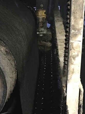 The VEGAPULS 64 radar sensor for liquid level measurement hangs over the asphalt tray.