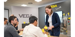 Vega Mitarbeiterin zeigt Schulungsteilnehmer einen Vega Sensor